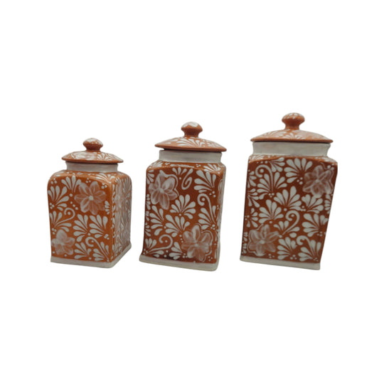 Brown and white floral Talavera canister trio on a white background