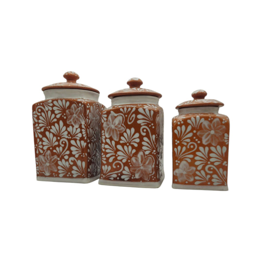 Angled view of a brown and white floral Talavera canister set