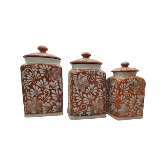 Brown and white Talavera canisters showing floral decorative patterns