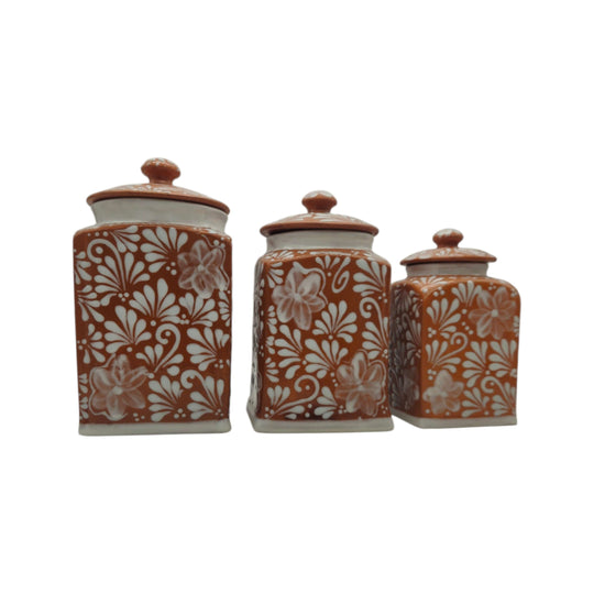 Front view of three brown and white Talavera canisters with lids