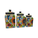 Front view of three colorful Talavera canisters with lids on a white background
