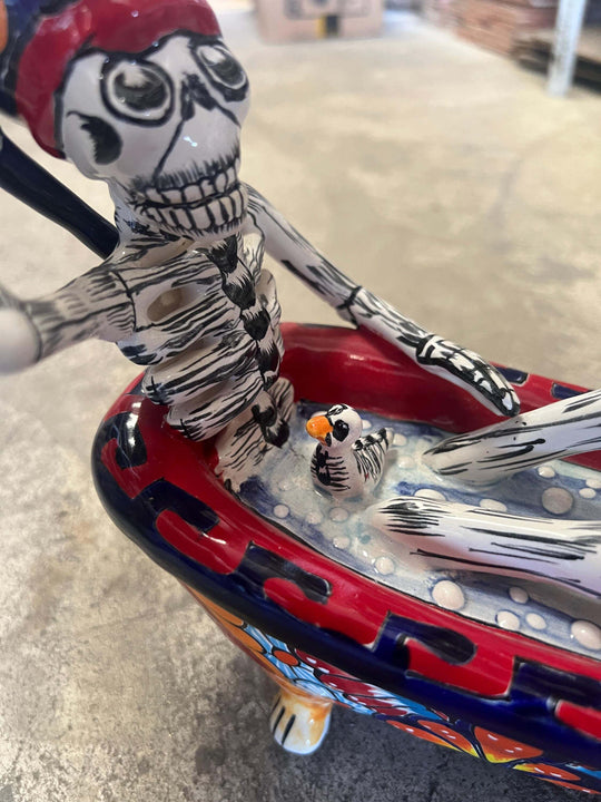 Talavera Skeleton Figurine | Day of the Dead Bathtub Statue showing hand-painted skeleton in floral Talavera clawfoot tub with small bird detail