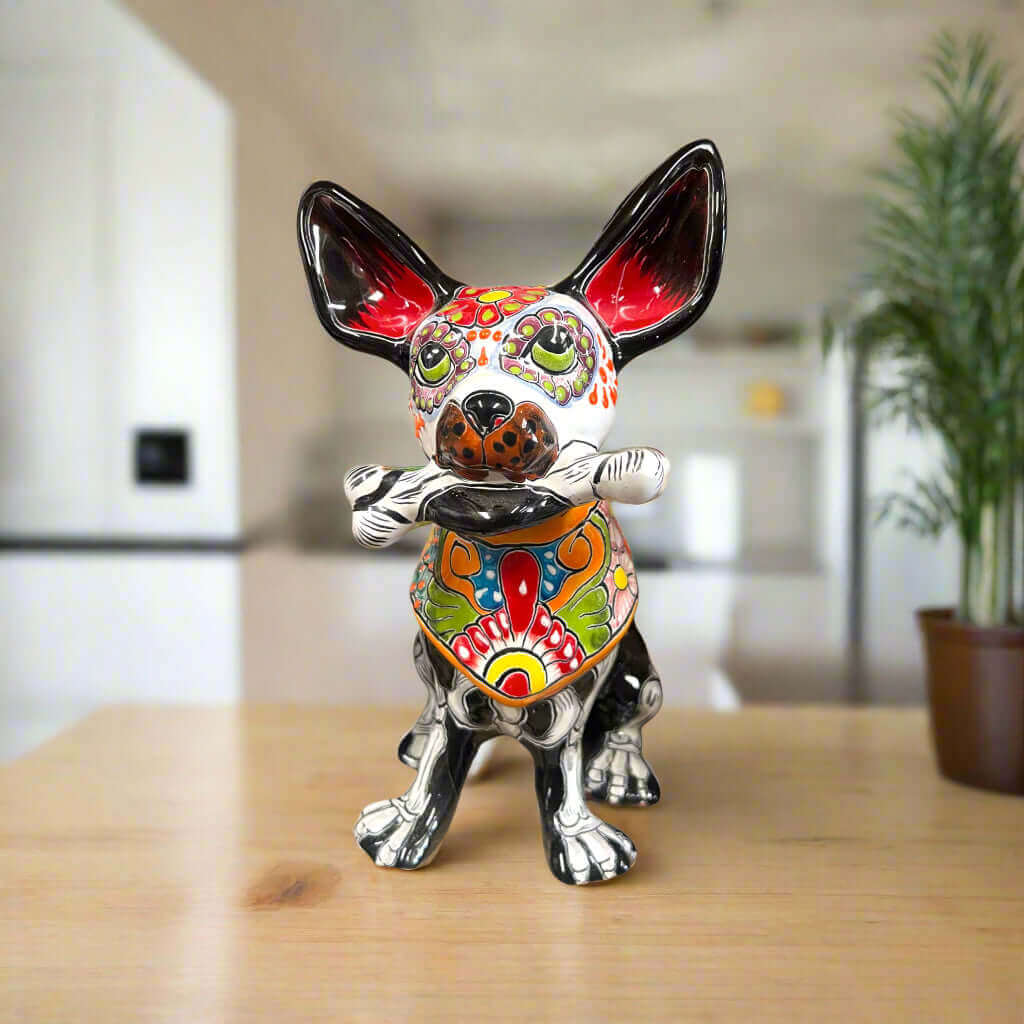 Talavera Chihuahua Holding Bone | Day of the Dead Dog Figurine - hand-painted Talavera chihuahua with floral skull design holding a bone