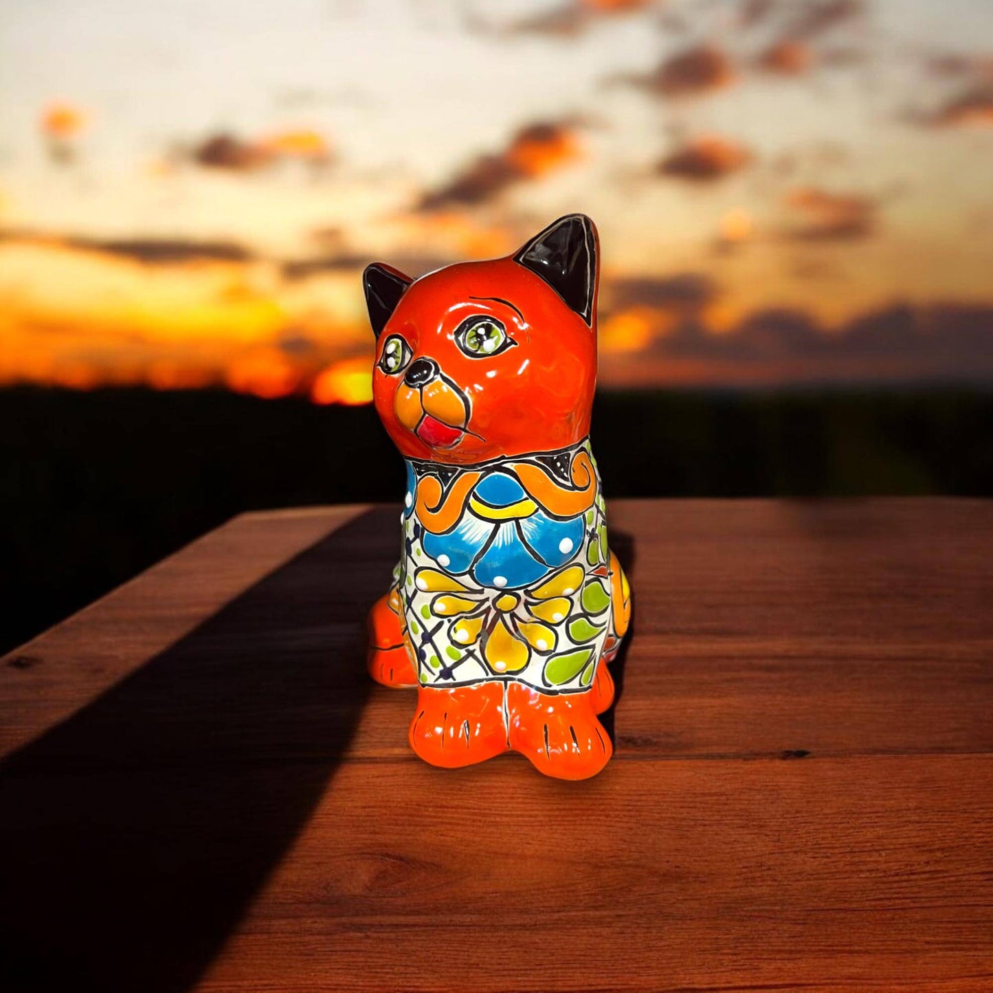 Talavera Cat Figurine | Hand-Painted Mexican Folk Art Home Decor — vibrant orange hand-painted Talavera cat with floral patterns on wood table at sunset