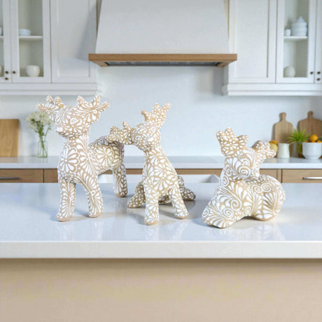 Talavera Reindeer Trio | Hand-Painted Christmas Relief Set - three handcrafted neutral-tone Talavera reindeer with floral relief patterns on kitchen counter