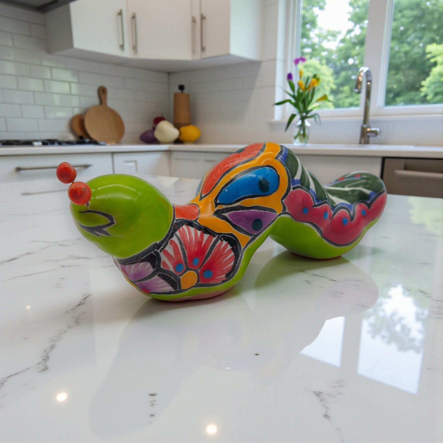 Talavera Caterpillar Art | Handcrafted Mexican Ceramic Figurine bright hand-painted orange and green Talavera caterpillar on kitchen counter