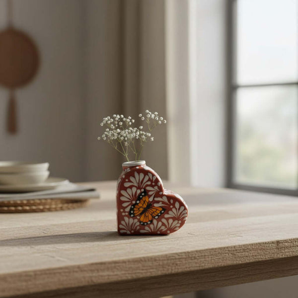 The Talavera Hub brown and white heart-shaped ceramic vase with a hand-painted butterfly design and delicate white flowers.