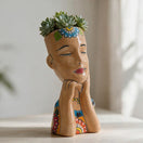 Side view of a hand-painted Talavera lady face planter with succulents
