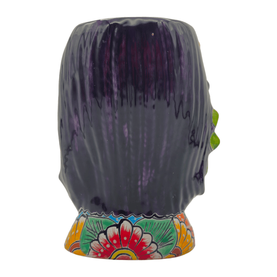 Back view of a Talavera lady face planter showing dark hair and floral base decoration