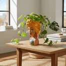 Side view of colorful Talavera lady head planter with trailing houseplant