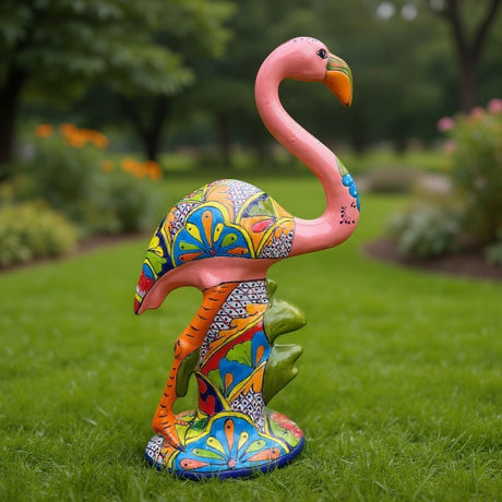 Colorful flamingo statue on grass with blurred greenery in the background