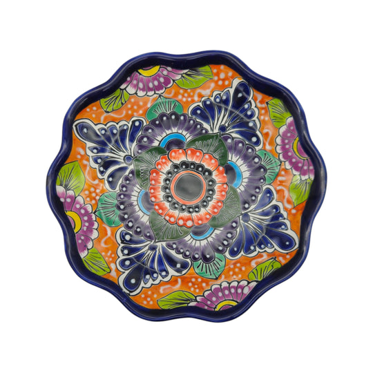 Front view of a colorful Talavera plate with orange floral background and blue accents