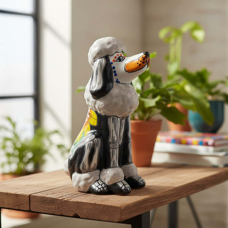 The Talavera Hub gray and black ceramic poodle statue with Day of the Dead painted details, orange nose, and floral accents.