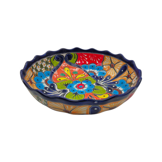 Colorful hand-painted Talavera scalloped ceramic bowl on a white background