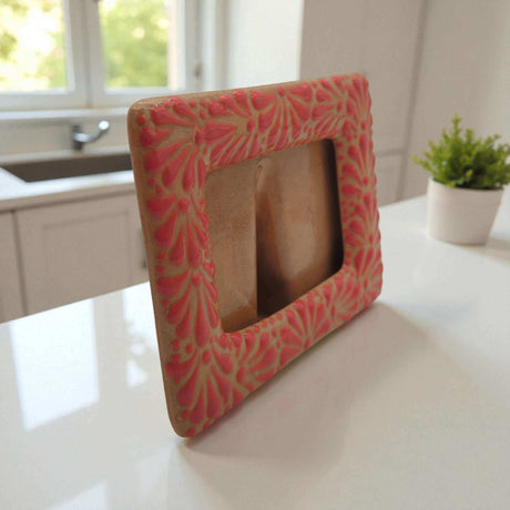 Talavera Terracotta Photo Frame | Pink Floral Accent handcrafted terracotta frame with pink floral motifs on kitchen counter