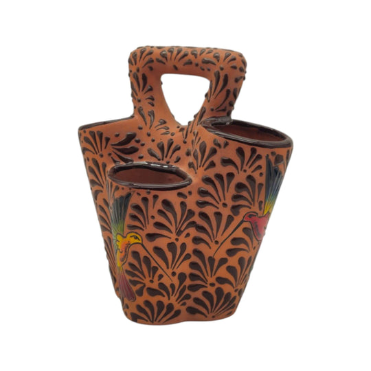 Side view of brown Talavera utensil holder with relief pattern and bird design