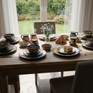 The Talavera Hub 43-piece Talavera dinnerware set with vibrant floral patterns, including plates, bowls, and mugs.