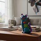 The Talavera Hub hand-painted ceramic Alebrije sitting cat statue with vibrant Mexican folk-art patterns on a table.