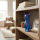 The Talavera Hub hand-painted ceramic Alebrije sitting dog statue with vibrant blue Mexican folk art patterns.