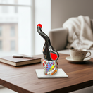 The Talavera Hub black ceramic elephant statue with colorful hand-painted butterfly and floral designs, red accents.