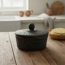 The Talavera Hub black ceramic tortilla keeper with carved floral motifs and a decorative lid knob. Handcrafted in Mexico.