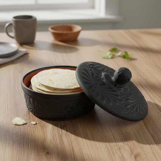 The Talavera Hub black ceramic tortilla keeper with carved floral motifs and a matte finish. Handcrafted in Mexico.