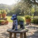 The Talavera Hub handmade blue and white ceramic donkey planter with intricate floral patterns on a wooden stool.