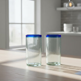 The Talavera Hub hand-blown clear glass tumblers with cobalt blue rims. Set of 2, 18 oz capacity, 6" tall.