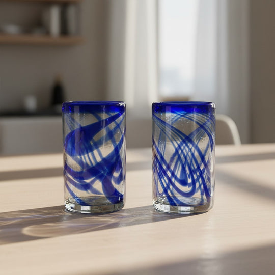 The Talavera Hub blue swirl hand-blown glass tumblers. Set of two recycled glass drinking glasses with cobalt blue swirls.