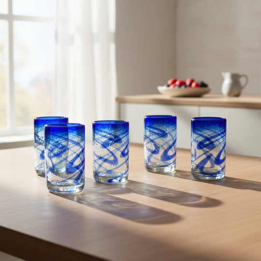 The Talavera Hub blue swirl hand-blown recycled glass tumblers, set of 6. Each 16oz glass features cobalt blue swirls on clear glass.