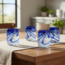 The Talavera Hub hand-blown stemless wine glass with blue swirls, made from recycled glass.