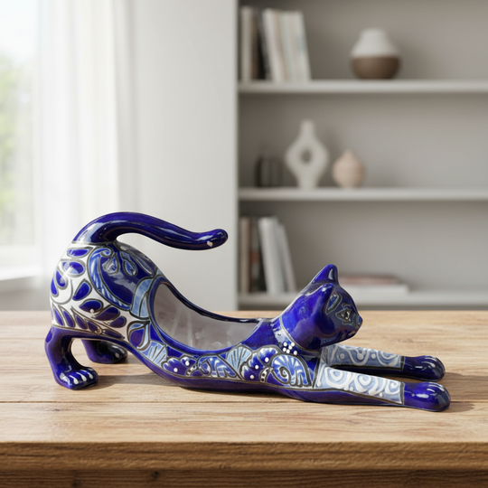 The Talavera Hub hand-painted blue Talavera cat planter with white floral details, stretching pose.