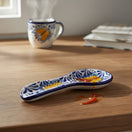The Talavera Hub blue and white ceramic spoon rest with monarch butterfly motif. Handcrafted Mexican Talavera pottery.