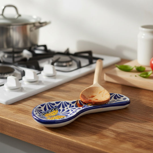 The Talavera Hub blue and white ceramic spoon rest with monarch butterfly motif and a wooden spoon.