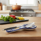 The Talavera Hub blue and white ceramic spoon rest with monarch butterfly motif, holding a spoon and fork.