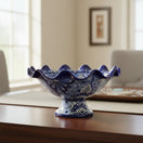 The Talavera Hub hand-painted blue and white ceramic fruit basket with ruffled edge and pedestal base.