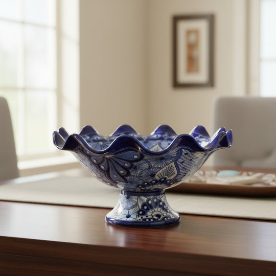 The Talavera Hub hand-painted blue and white ceramic fruit basket with ruffled edge and pedestal base.