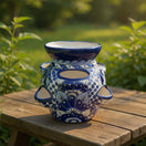The Talavera Hub handmade ceramic strawberry planter with blue and white floral patterns on a wooden garden table.