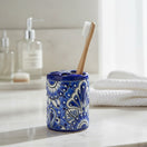 The Talavera Hub hand-painted ceramic toothbrush holder in blue and white with traditional floral Mexican motifs.