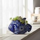 The Talavera Hub handcrafted blue and white ceramic fish planter with intricate floral patterns holding a succulent.