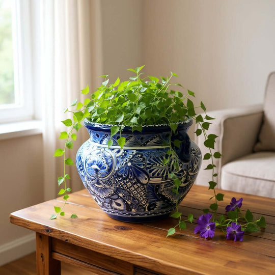 The Talavera Hub handmade Talavera planter with intricate blue and white floral patterns and a cobalt rim on a table.