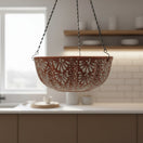 The Talavera Hub brown and white ceramic hanging planter with intricate floral motifs suspended by black metal chains.
