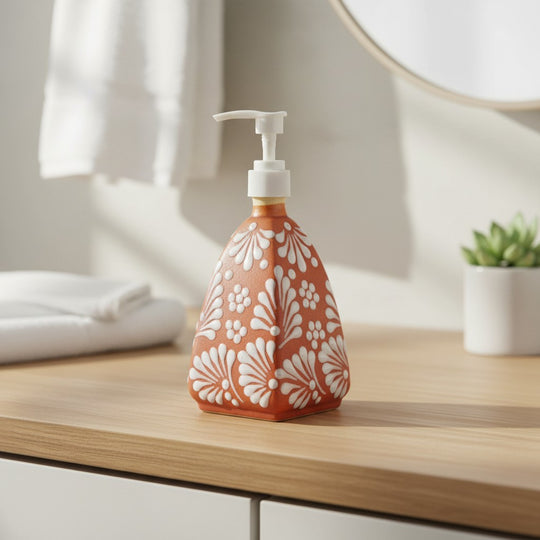 The Talavera Hub hand-painted ceramic soap dispenser with a brown and white pyramid pattern on a wooden countertop.