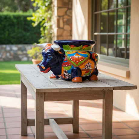 The Talavera Hub's vibrant blue ceramic bull planter with hand-painted floral details in orange, green, and yellow.