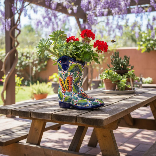 The Talavera Hub hand-painted Mexican ceramic boot flower pot with butterfly and floral patterns on a wooden table.