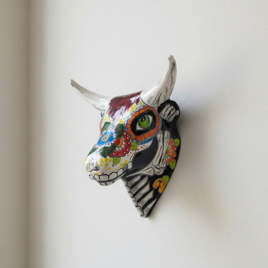 The Talavera Hub handcrafted ceramic bull skull wall art with vibrant Day of the Dead floral and skeletal patterns.