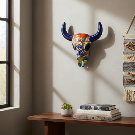 The Talavera Hub handmade ceramic bull skull wall decor with vibrant floral and geometric patterns in a home interior.