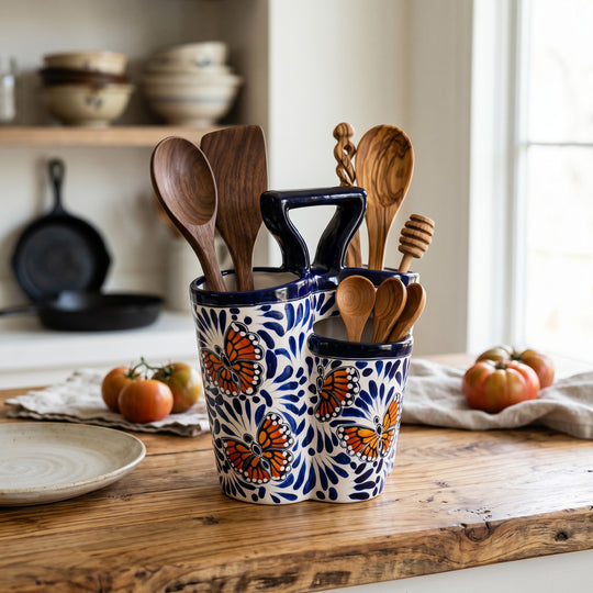 The Talavera Hub handmade ceramic utensil holder with blue and white butterfly design on a wooden kitchen counter.