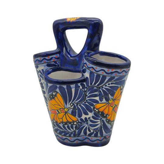 The Talavera Hub handmade ceramic utensil holder with blue and white butterfly patterns and a central handle.