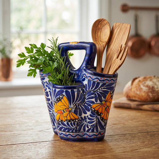 The Talavera Hub handmade ceramic utensil holder in blue and white with hand-painted orange butterfly folk art design.